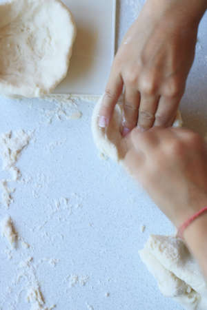 childs hands with dough over the table, top viewの写真素材