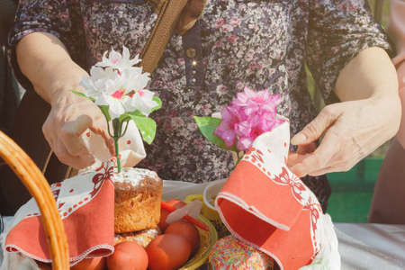 Holding a ceremony on the street on the occasion of the end of Lent. The woman decorated Easter eggs and a festive cake on the table.の写真素材