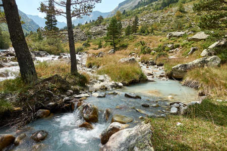 Mountain river landscape. Alps. In the morning in clear sunny day on a wide corner. The river quickly flows. Mountaineering and hikes. Flow. Wide angle.の写真素材