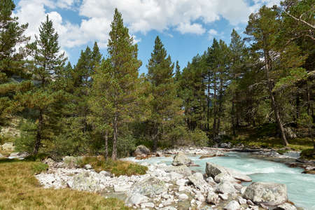 Mountain river water landscape. Alps. The cloudy sky in clear sunny day. Warm summer. Time for pedestrian tourism and family holiday with friends. Nature. Green.の写真素材