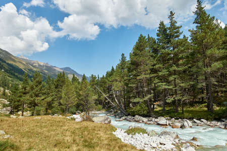Mountain river water landscape. Alps. The cloudy sky in clear sunny day. Warm summer. Time for...
