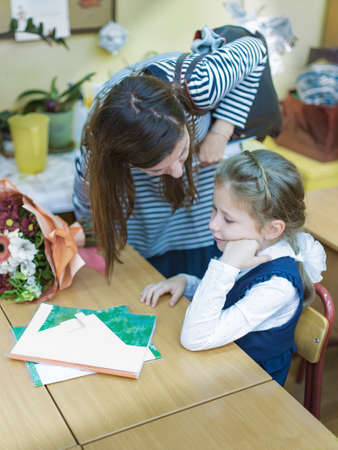Mother says goodbye to her daughter a primary school student and leaves her in the classroom.の写真素材