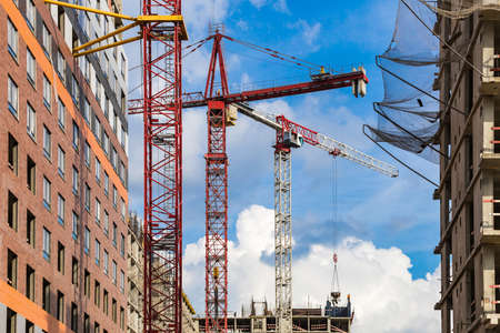 Several red cranes have been put to work on the construction of a modern multi-storey residential...