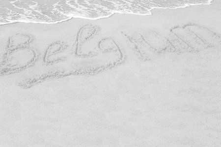 Grey, wet, sea wave washed up on the beach in the summer morning. Inscription beach country Belgium on the coast of Europe. Space for text and drawing. backdrop; background; beach; holidayの写真素材