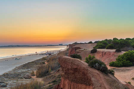 Sunset Praia da Falesia, big beach, beautiful orange cliffs and colorful skyの写真素材