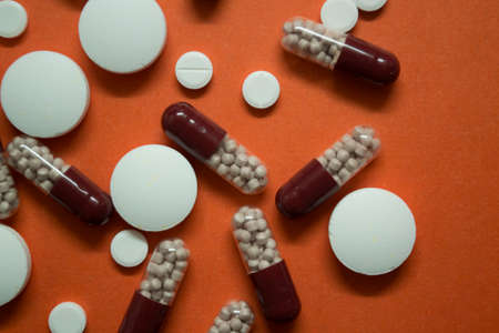 pills and a thermometer are on the tableの写真素材