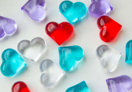 glass multicolored hearts lie on a white backgroundの写真素材