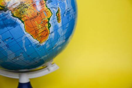 globe sphere on the yellow background, place for text, travel concept around the world