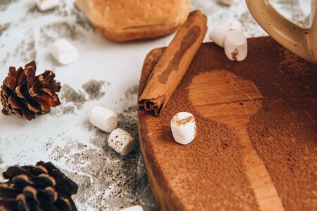 Christmas New Year marshmallows sprinkled with cocoa powder on the wooden board, shape of spoon,...