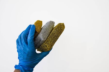 Hand in rubber holding cleaning sponges isolated on white, Copy space, General cleaning, Banner for cleaning companyの写真素材