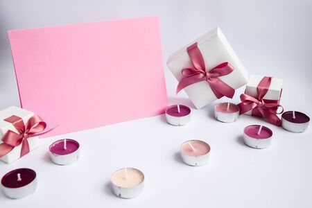 Pink copy space for text with gift boxes and candles around, holiday concept, greeting card
