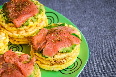 Snacks from rice cookies, salmon, avocado and spices on plate, Healthy snack , Breakfast, Vegetarian...
