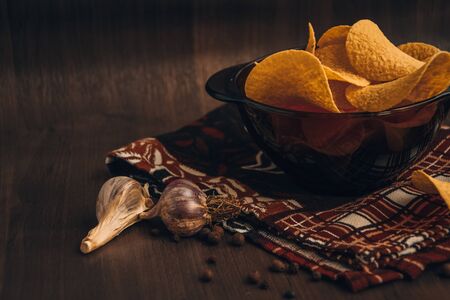 Delicious Crispy potato chips in bowl on wooden background, Copy space, Fast food, Snack, Garlic...