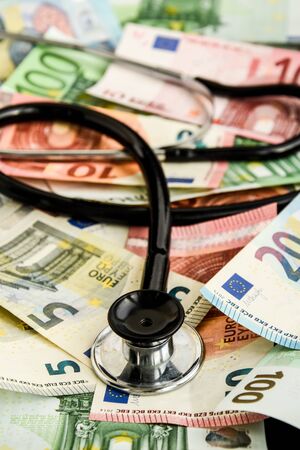 stethoscope and the euro banknotes, Medical cost concept - Stethoscope on euro paper money bank notes Euro banknotes background : Banking Account, Investment Analytic research data economy, trading, Business company concept.の写真素材