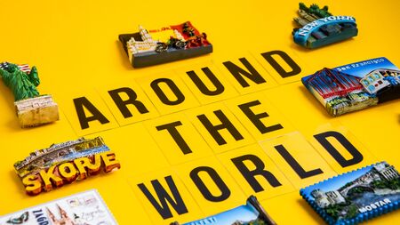 Text Around the world Magnets from different countries on yellow background, travel concept, planning tripの写真素材