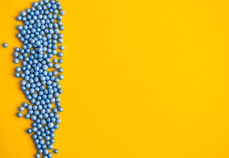 Colorful sprinkles in blue on yellow background with copy space for text, party yellow background with blue confettiの写真素材