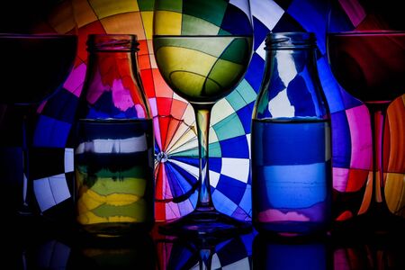 wine glasses and bottles in a row with colorful light painting behind, Set of wine glasses with red, white and rose wine, banner, alcohol drinksの写真素材