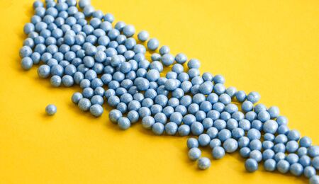 Colorful sprinkles in blue on yellow background with copy space for text, party yellow background...