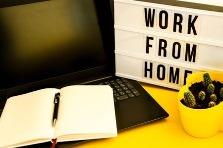 Text WORK FROM HOME with notebook, laptop and pen, cactus, work from home place, freelance...
