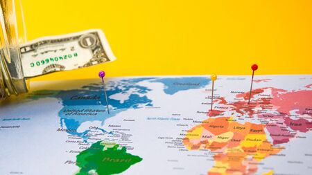 Money is the most important thing on planet Earth, US dollars and world map, travel concept, world and moneyの写真素材