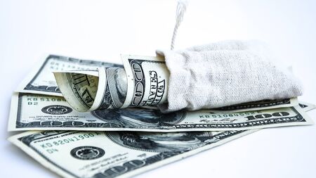 Bag with money isolated on white, Hundred dollar bills in a canvas sack, Banknotes money dollars in the bag, copy space for textの写真素材