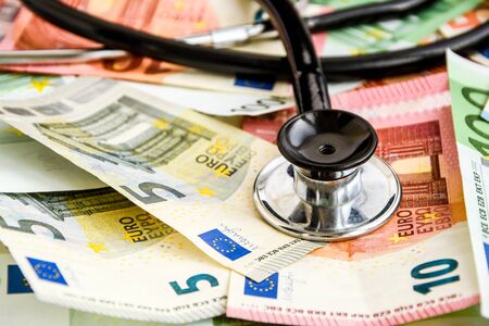 stethoscope and the euro banknotes, Medical cost concept - Stethoscope on euro paper money bank notes Euro banknotes background : Banking Account, Investment Analytic research data economy, trading, Business company concept.の写真素材