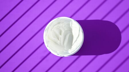 white cream in a bowl on blue background with deep shadow, Jar of cream with a shadow, Face...