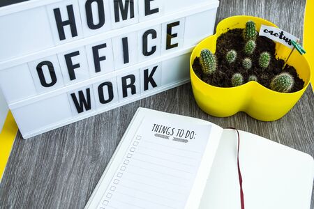 lightbox with text HOME OFFICE WORK with notebook pen and cactus and TO DO list, copy space wooden table background, quarantine and isolation HOME OFFICE, coronavirus, europeの写真素材