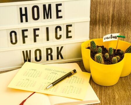 lightbox with text HOME OFFICE WORK with notebook calendar 2020 pen and cactus and TO DO list, copy space wooden table background, quarantine and isolation HOME OFFICE, coronavirus, europeの写真素材
