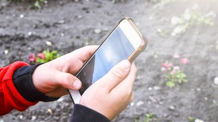 Small boy with smartphone in his hands is mastering new technologies, taking photos, small photographer, selective focusの写真素材