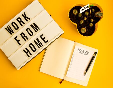 lightbox with text WORK FROM HOME with notebook pen and cactus and TO DO list, copy space on yellow background, quarantine and isolation HOME OFFICE, coronavirus, europeの写真素材