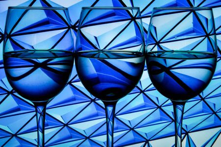 Three wine glasses in a row with dark light painting behind, Set of three wine glasses with red, white and rose wine, banner, alcohol drinksの写真素材