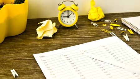 Agenda, hour by hour planner with alarm clock and office supplies. Business planning, workplace. paperの写真素材