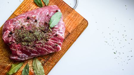 Top view of Fresh meat with bay leaf on wooden cutting board, Raw meat. Fresh beef, copy space, rump steakの写真素材