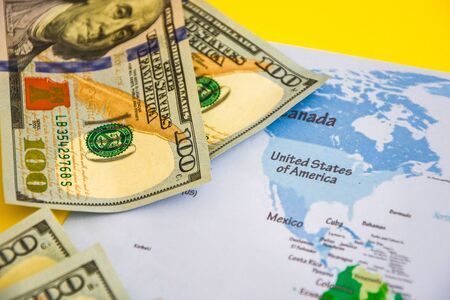 Pile of dollars near USA on world map, money, dollar and world map view from above. Text field, Copy space, US dollar banknotes on globe world mapの写真素材