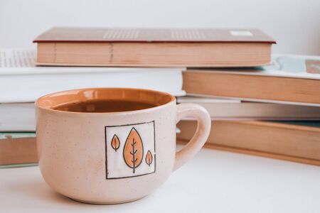 Stack of old book education concept background, many books piles with copy space for text, Book tops, Old and used hardcover books, top view. Educational concept. Close up, cup of hot teaの写真素材