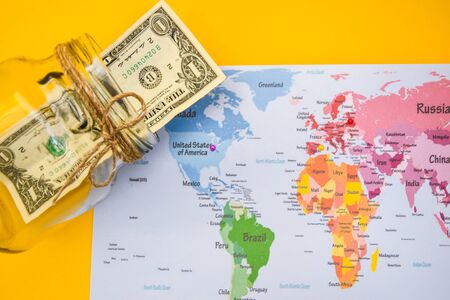 Money is the most important thing on planet Earth, US dollars and world map, travel concept, world and moneyの写真素材