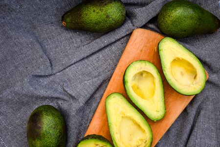 Halves fresh avocado, Ripe avocado and cut avocado with bone. Ripe autumn pears in a wooden crate, Top view, copy spaceの写真素材