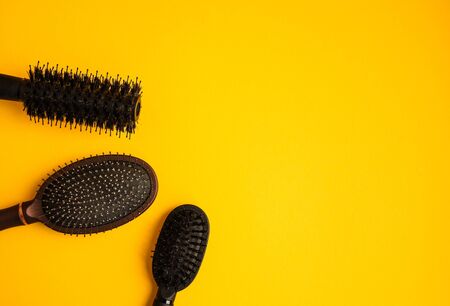 Combs and hairdresser tools in beauty salon work desk on yellow background top view space for text, professional toolsの写真素材
