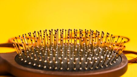 Combs and hairdresser tools in beauty salon work desk on yellow background top view space for text,...