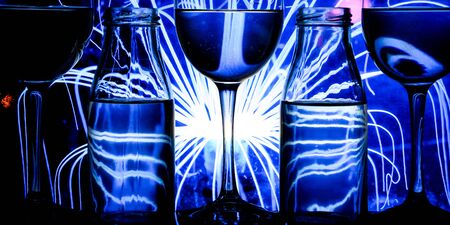 wine glasses and bottles in a row with colorful light painting behind, Set of wine glasses with red, white and rose wine, banner, alcohol drinksの写真素材