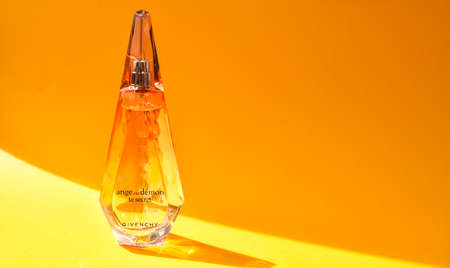 Zhytomyr, Ukraine - June 2, 2020. A clear orange glass spray bottle of Givenchy Ange ou Demon Le...
