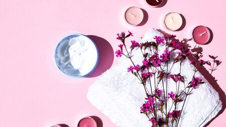 Spa still life treatment with candles, stones, sea shells starfish and towels on pink background, copy space for text, skincare products, natural cosmetics for home spa treatmentの写真素材