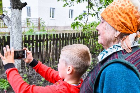 Happy grandmother and grandson taking selfie photo. concept of happy family, Video call in home garden, three generations, Multi-Generationの写真素材