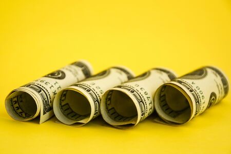 American dollars in rolls. Saving money concept on yellow background with copy space for text, Background from the dollar. American money. The American account, Savings and Wealthの写真素材