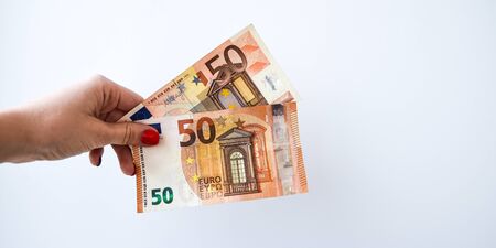 Woman's hand with 50 euros money on a white background, copy space for text, Close up of female hands counting 50 euro banknotes isolated on white backgroundの写真素材