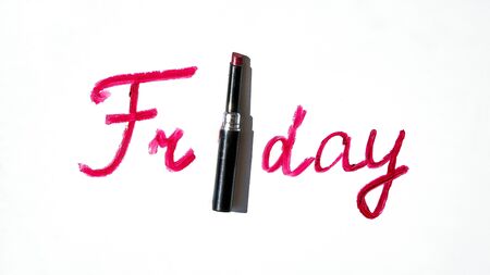 Red lipstick with Friday text, Creative concept photo of lipstick with sign friday on white...