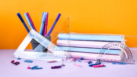 School subject books with supplies on color background, back to school. Stationery ruler pencil paper clips work placeの写真素材