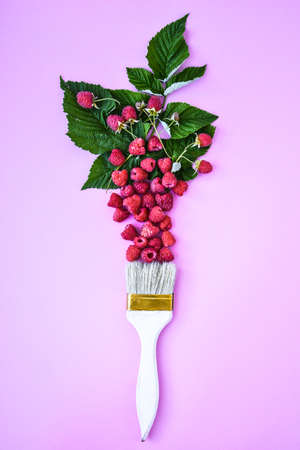 Creative food raspberry background with paintbrush. Ripe red raspberries. Summertime berries. Copy...