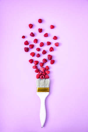 Creative food raspberry background with paintbrush. Ripe red raspberries. Summertime berries. Copy space. Art concept design berriesの写真素材